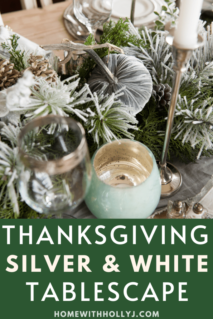 Sharing an Elegant Thanksgiving Tablescape featuring silver and white table settings, a garland table runner, and pumpkins with greenery.