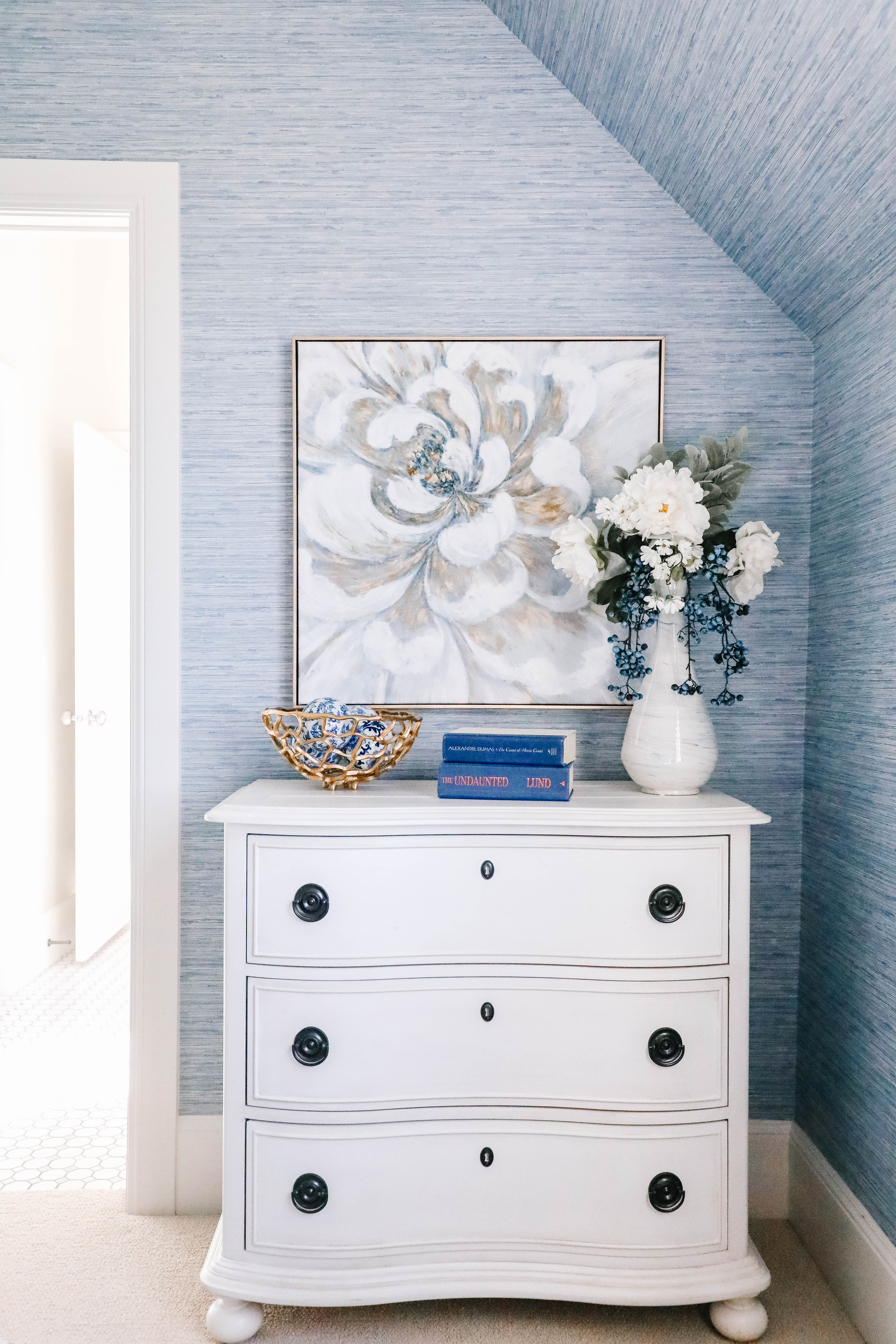 dresser artwork and floral arrangement