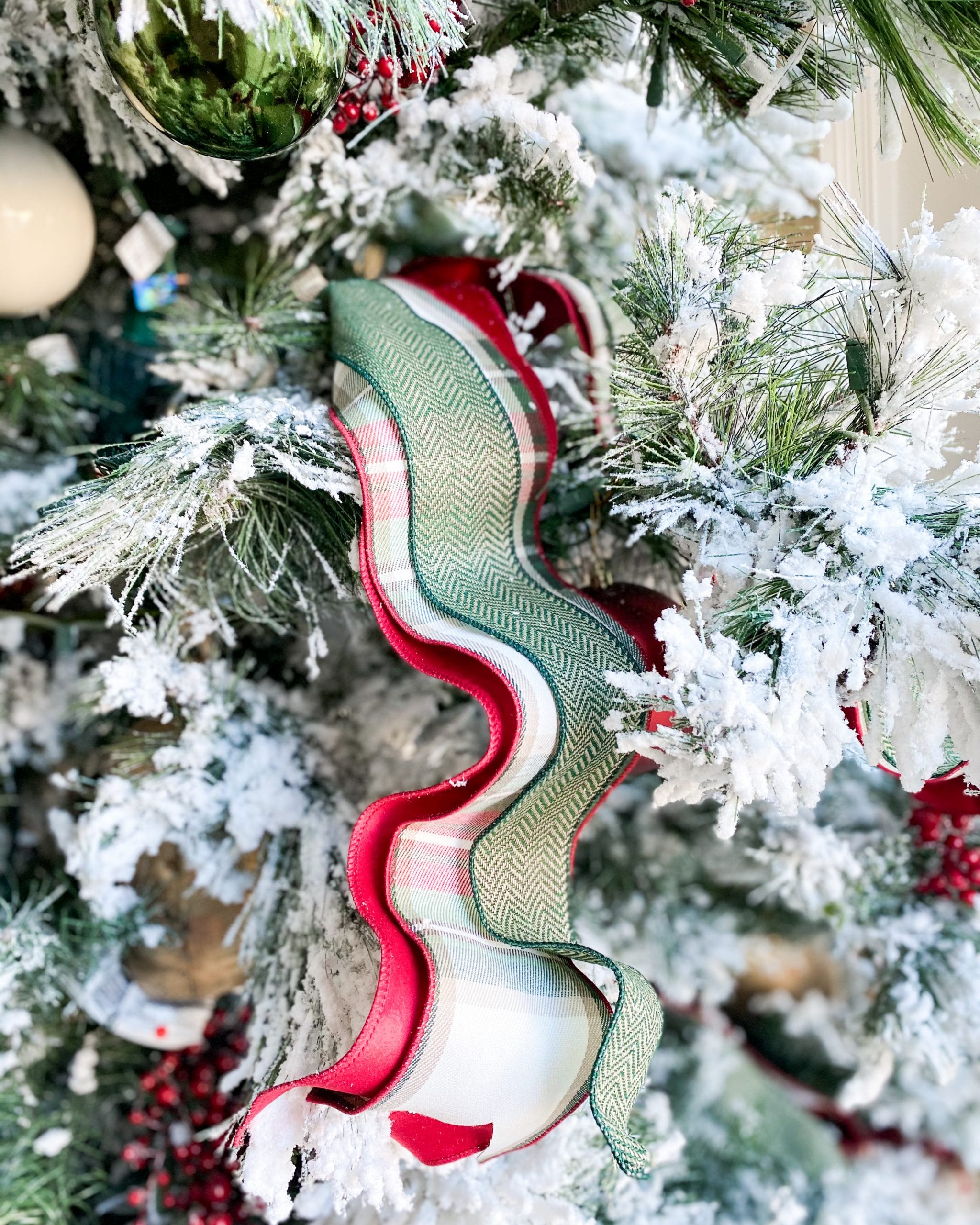 Christmas tree decorated with silver and white ribbons and