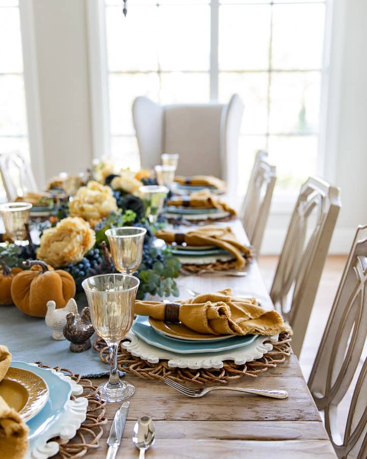 Thanksgiving Table Decor close up of light blue plates and mustard yellow napkins