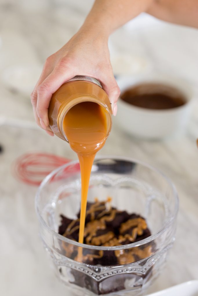 Salted Carmel Chocolate Trifle pouring caramel on trifle