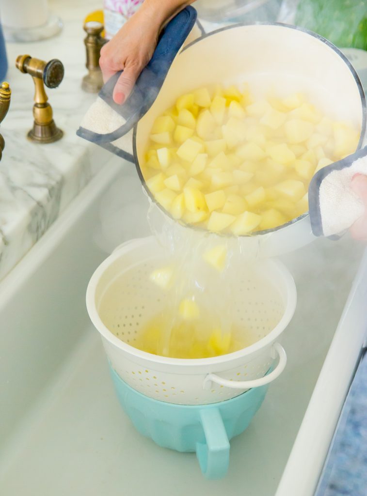 draining water from pot with potatoes