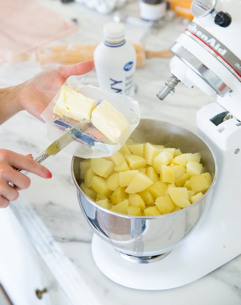 mashing potatoes in a stand mixer with butter