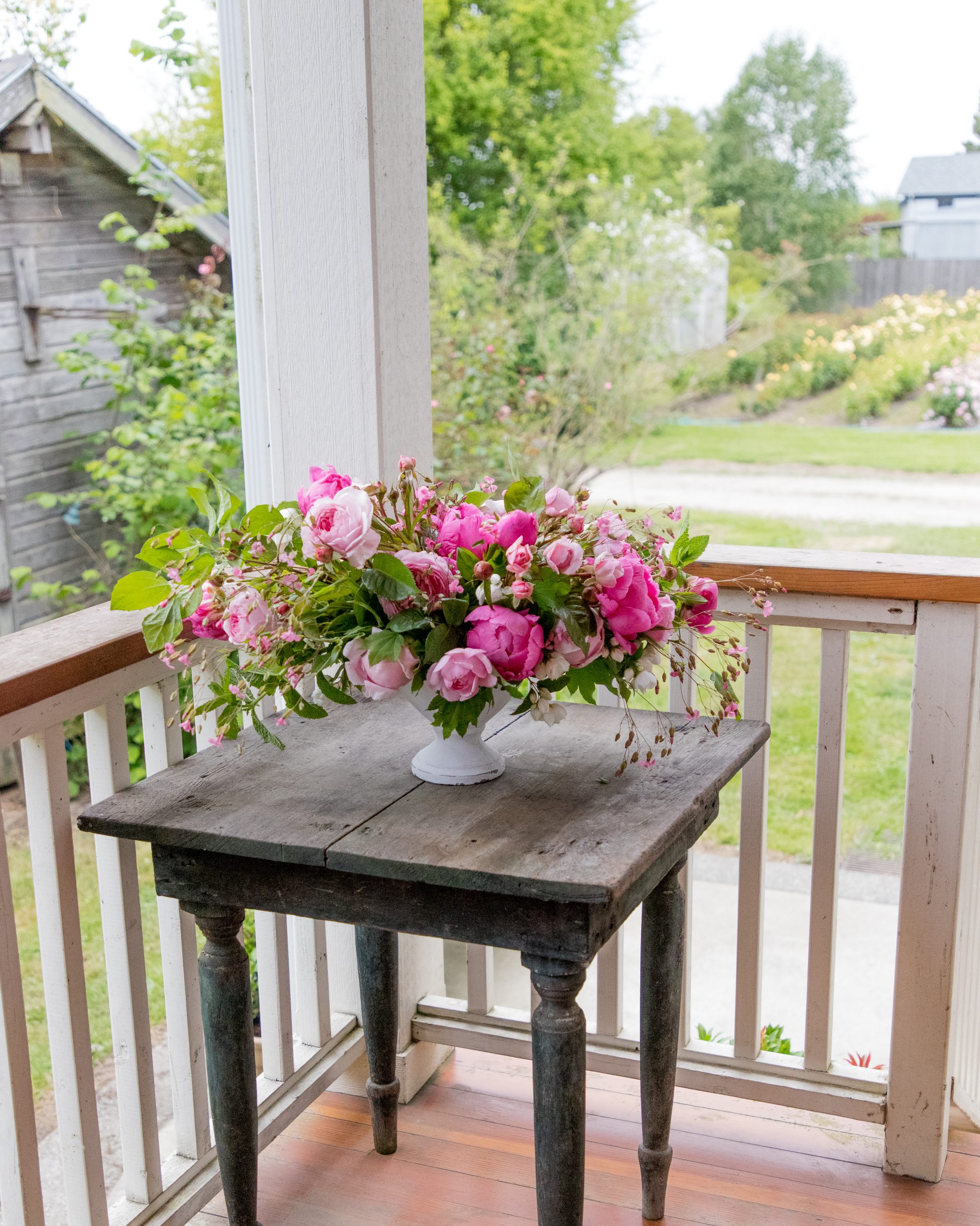 peonies arranged in a. compote vase