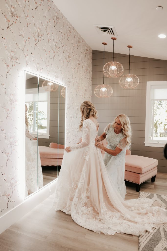 Planning a fall wedding - brides mom buttoning dress