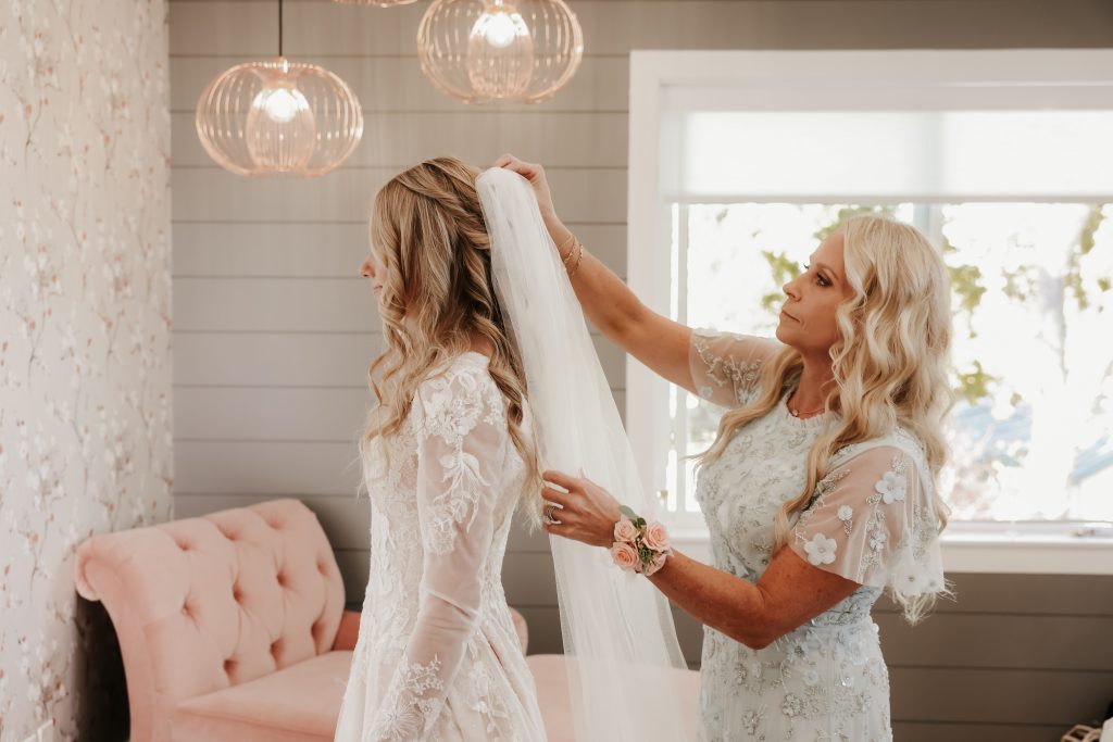 Planning a fall wedding - brides mom putting veil on