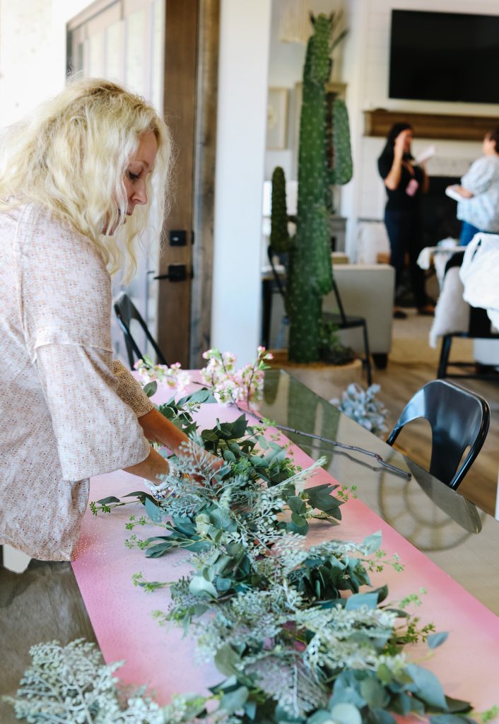 Woman putting a centerpiece together for a pink paper plate tablescape