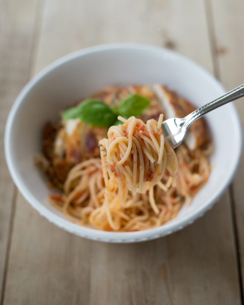 tomato butter pasta and crusted romano chicken dish