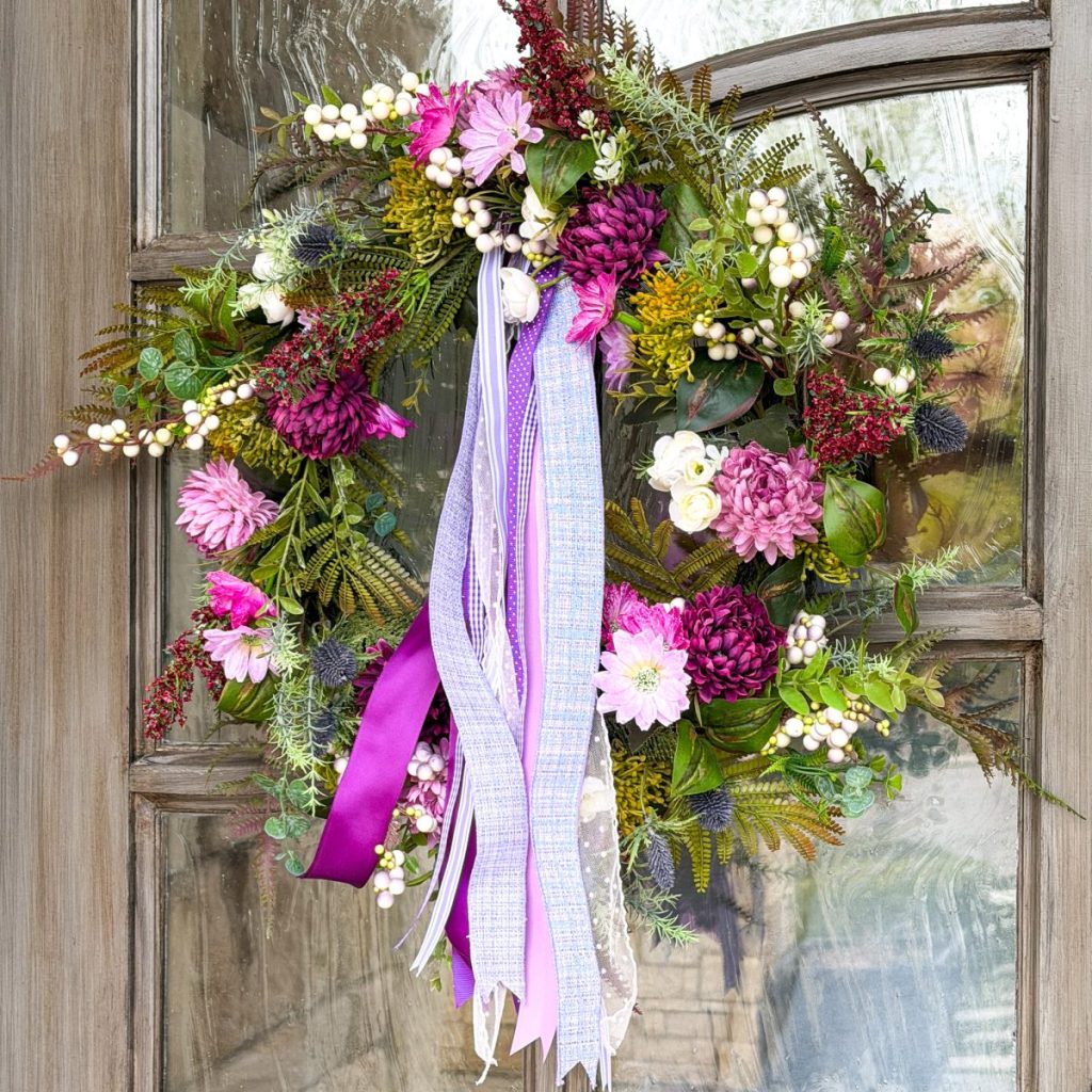 purple and pink with greenery spring door wreath with purple ribbon